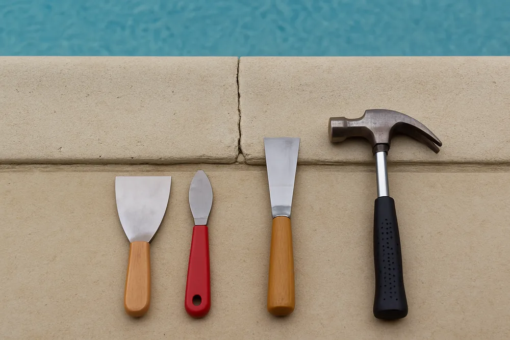 A close view of a pool coping edge with a hairline gap and a chipped corner — approval and repairs for an existing pool, Cairns. Illustrative example.